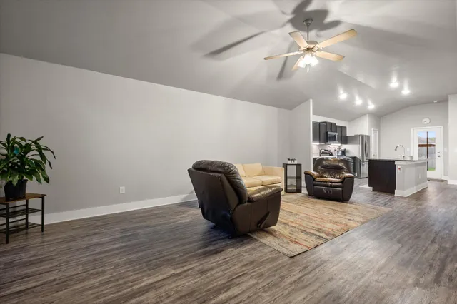 a living room with furniture and kitchen view