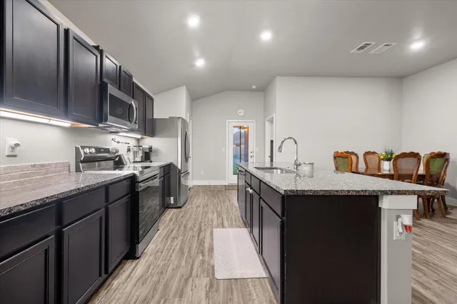 a kitchen with granite countertop a sink and cabinets
