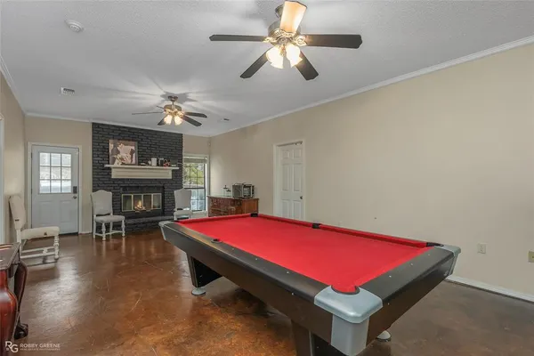 a room with pool table table and windows