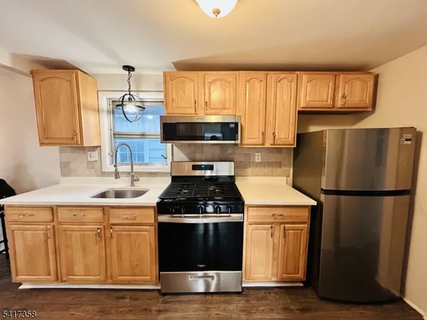 a kitchen with a stove a refrigerator and a sink