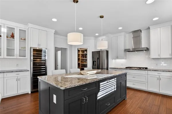 a kitchen with granite countertop a sink a counter space appliances and cabinets