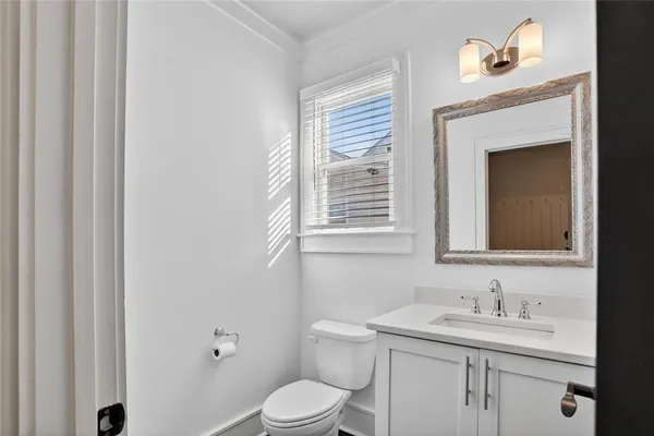 a bathroom with a toilet a sink and mirror
