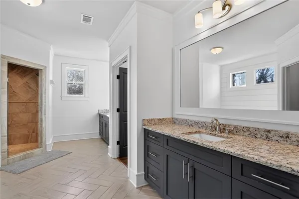 a bathroom with a granite countertop sink and a mirror