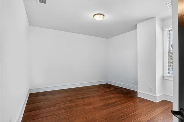 a view of an empty room with wooden floor