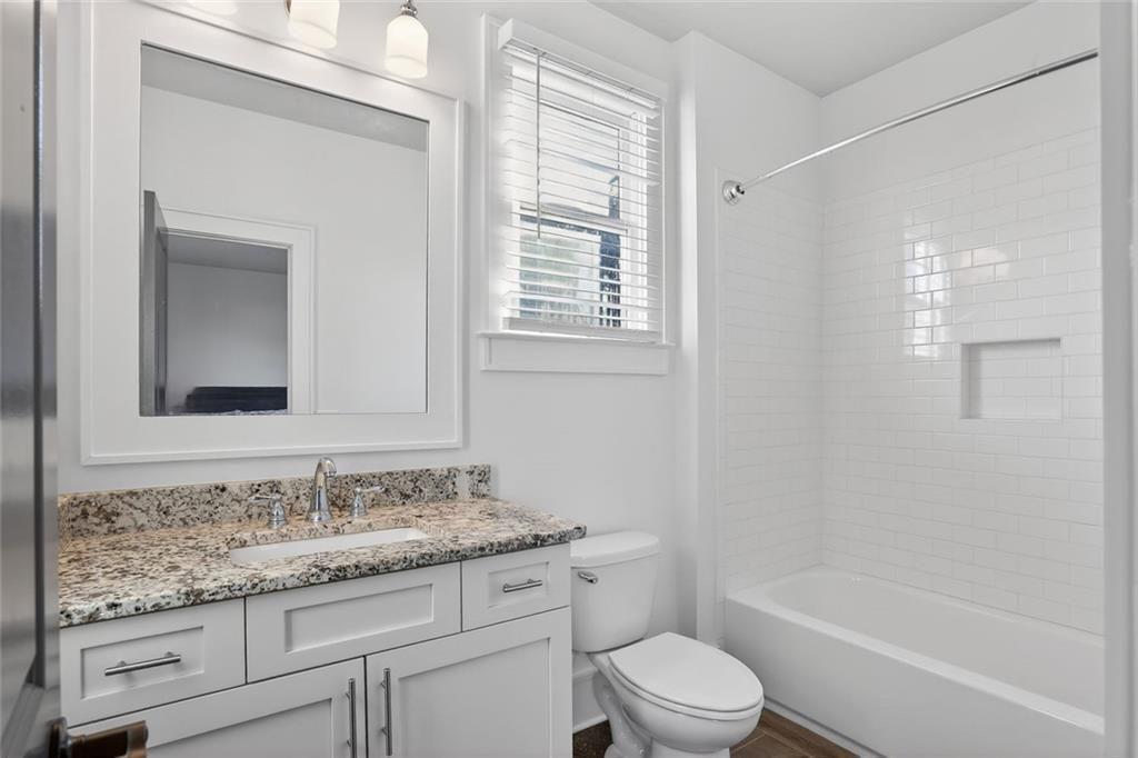 1311 Conway Road Decatur, GA 30030 - Photo 40 of 49 a bathroom with a granite countertop toilet a sink and a bathtub