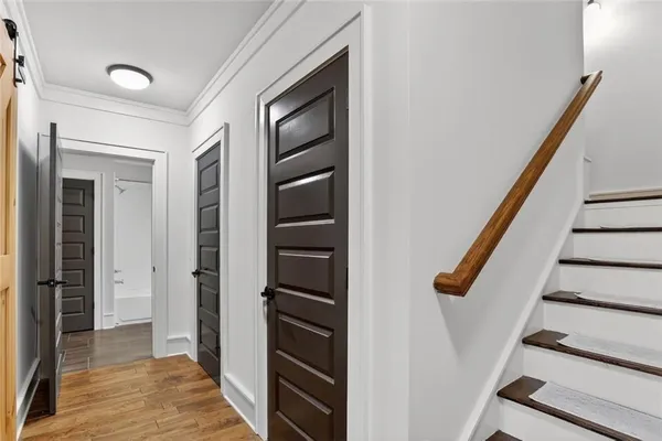 a view of hallway with stairs and wooden floor