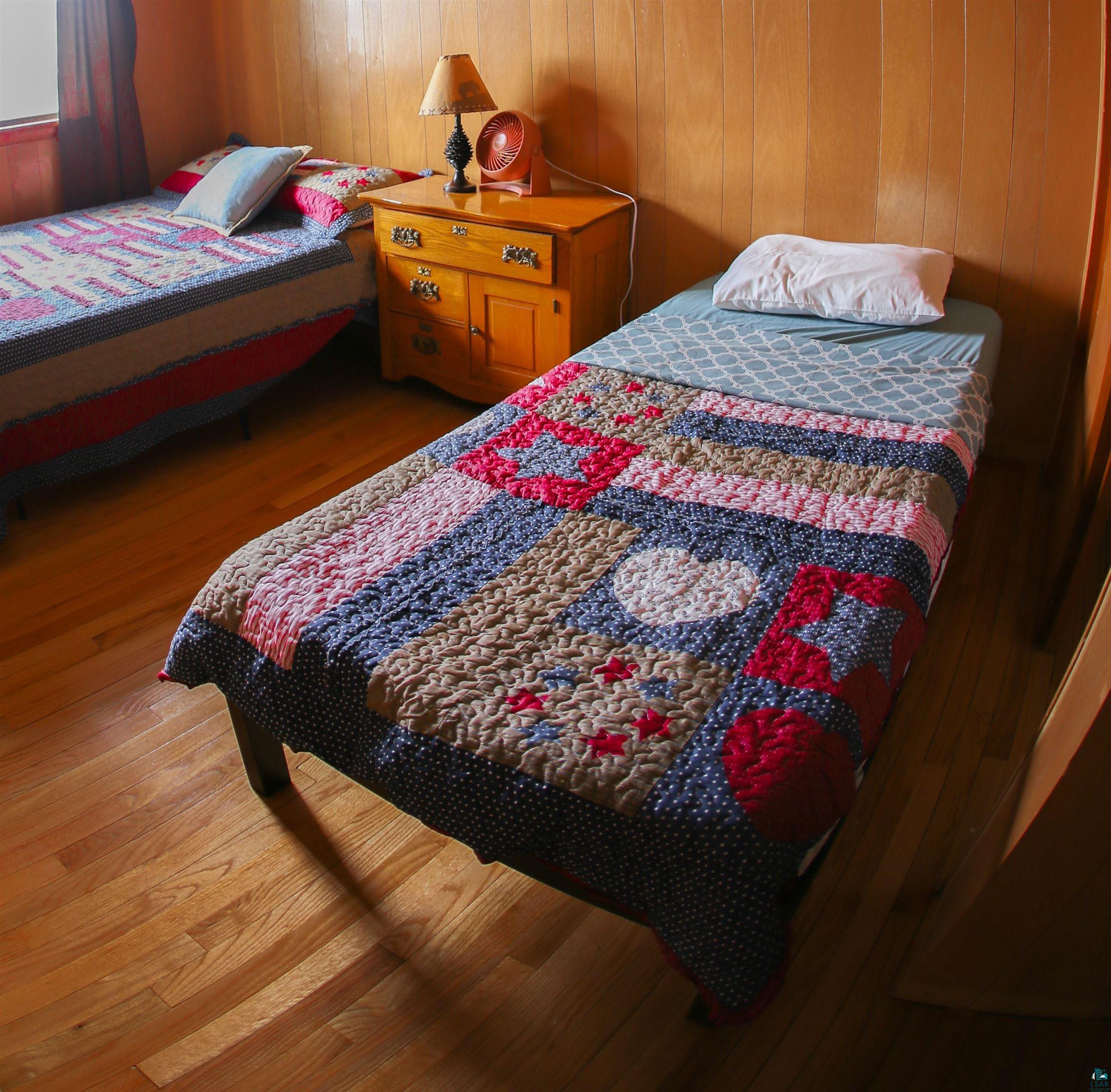 444 Fernberg Road, Unit 11 Ely, MN 55731 - Photo 5 of 19 Bedroom with wood finished floors and wooden walls