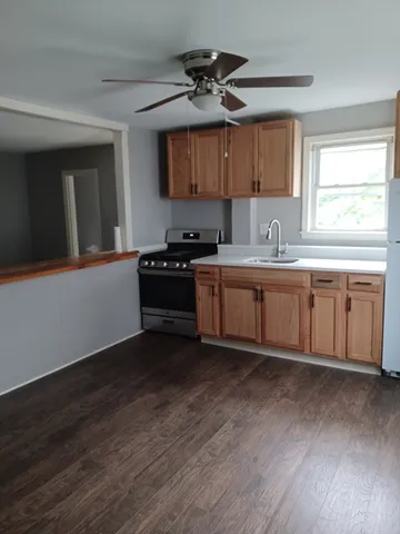 a kitchen with a sink cabinets and wooden floor