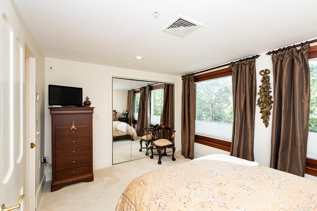 131 Nichols Road, Unit 8 Cohasset, MA 02025 - Photo 18 of 37 a bedroom with a bed and a flat tv screen on dresser