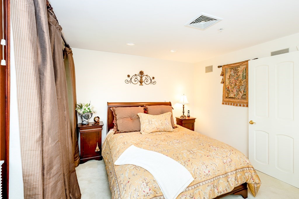 131 Nichols Road, Unit 8 Cohasset, MA 02025 - Photo 19 of 37 a bedroom with a large bed and a chandelier