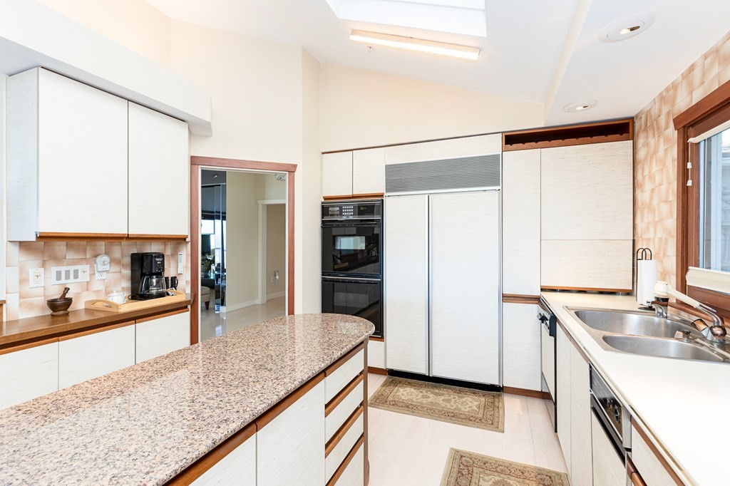 131 Nichols Road, Unit 8 Cohasset, MA 02025 - Photo 22 of 37 a kitchen with stainless steel appliances granite countertop a sink and a refrigerator