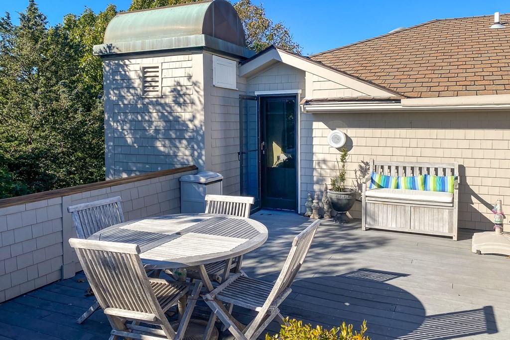 131 Nichols Road, Unit 8 Cohasset, MA 02025 - Photo 36 of 37 a view of a patio with table and chairs with wooden floor and fence