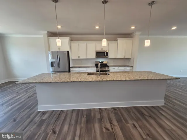 a view of kitchen with granite countertop window and wooden floor