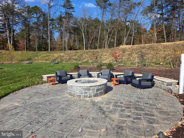 a view of a backyard with table and chairs plants and trees