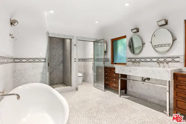 a bathroom with a sink mirror and a toilet