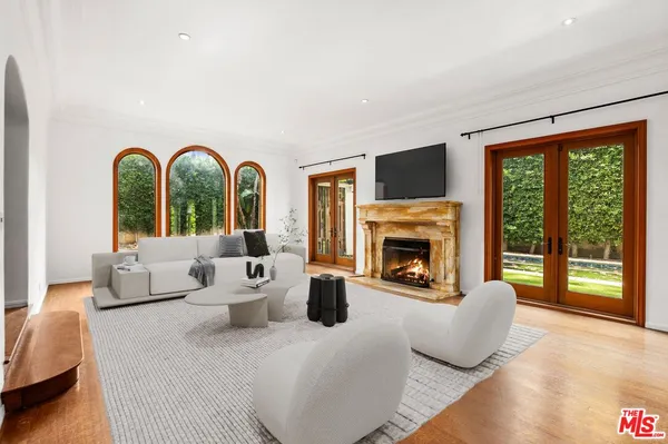 a living room with furniture a fireplace and a large window with garden view