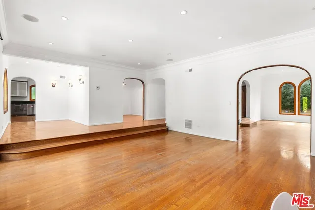 a view of a living room with kitchen island with wooden floor