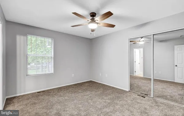 an empty room with fan and windows