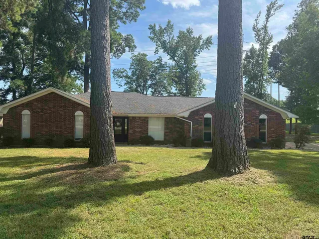 a view of a house with a tree in front of a yard