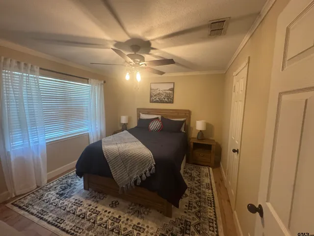 a bedroom with a bed and wooden floor