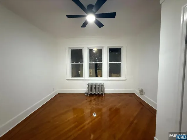 an empty room with wooden floor and a window