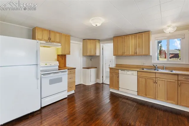 a kitchen with granite countertop white cabinets and white appliances