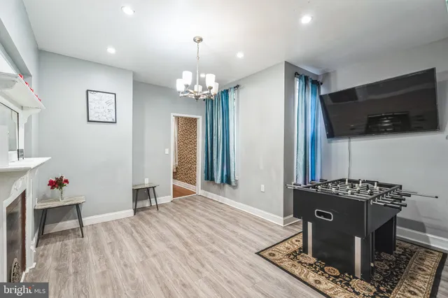 a view of a dining room with furniture a chandelier and wooden floor