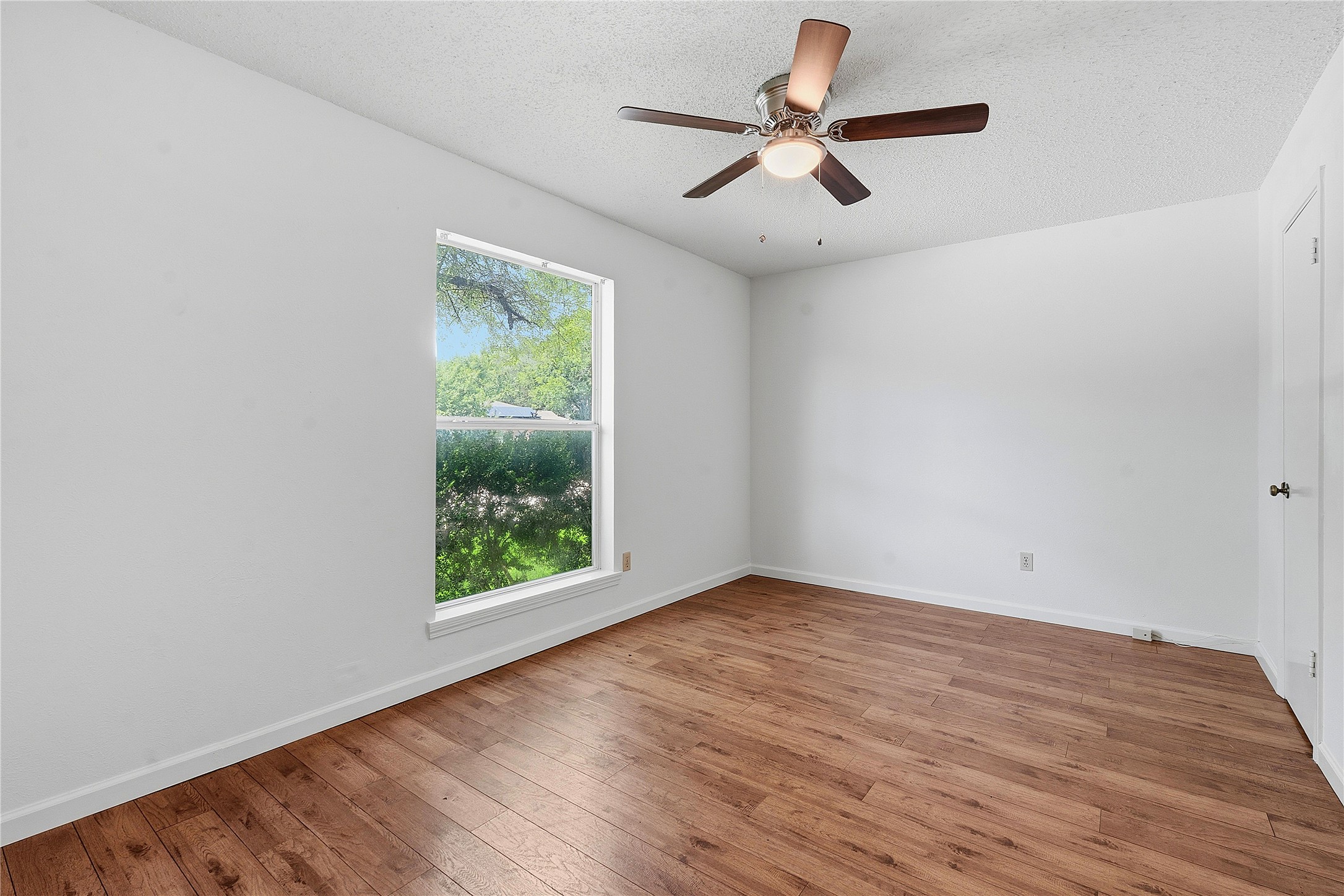 6205 Shadow Bend Austin, TX 78745 - Photo 14 of 31 Well-lit interior space with rich hardwood flooring and a stylish ceiling fan.