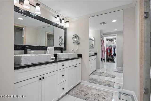 a spacious en suite bathroom with a double vanity sink and a mirror