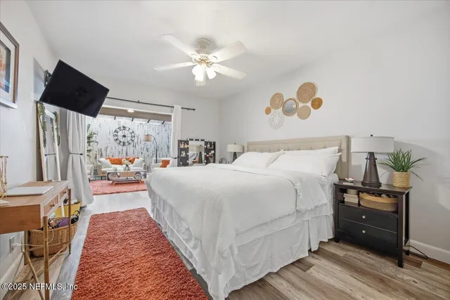 a bedroom with a large bed and a flat tv screen on dresser