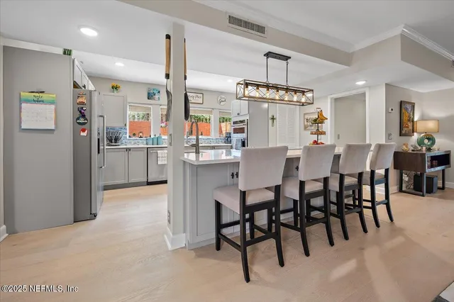 a dining area with furniture a kitchen and chandelier
