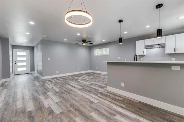 a view of a kitchen with kitchen island a sink stainless steel appliances and cabinets