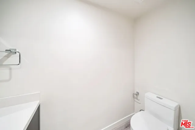 an empty room with wooden floor and bathroom