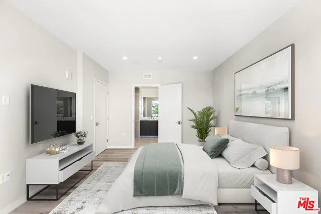 a bedroom with a large bed and a flat screen tv