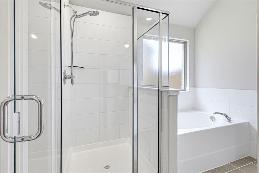 2108 Mossfield Lane Forney, TX 75126 - Photo 20 of 28 Modern bathroom featuring a glass-enclosed shower with white subway tile surround and an integrated shower niche