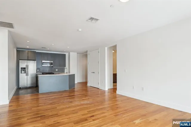 a large kitchen with a refrigerator and a stove top oven