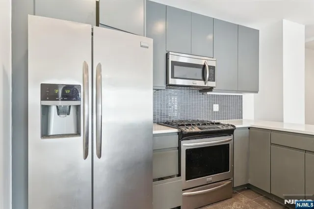 a kitchen with stainless steel appliances wooden cabinets and a stove