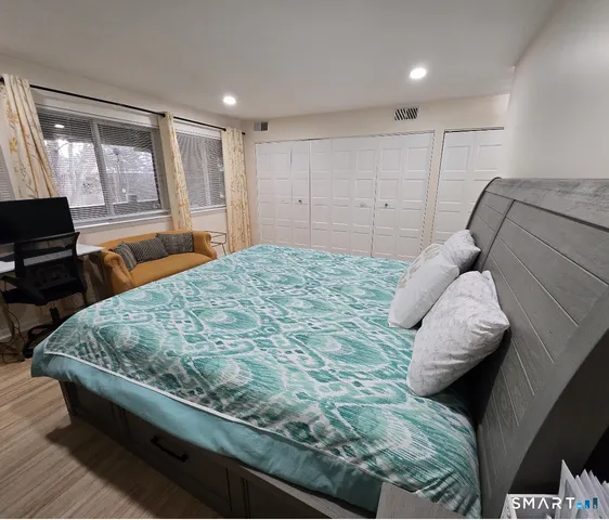 a bed sitting in a bedroom next to a window