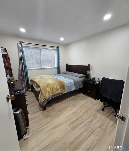 a bedroom with a bed and wooden floor