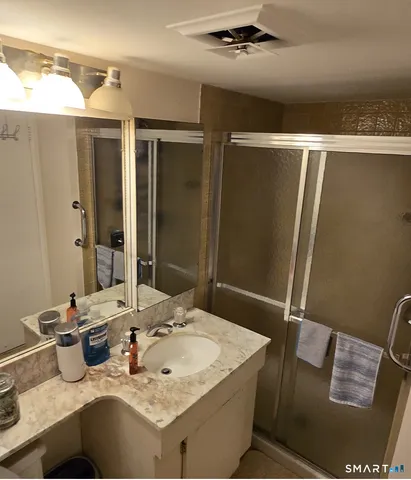a bathroom with a granite countertop sink and a mirror