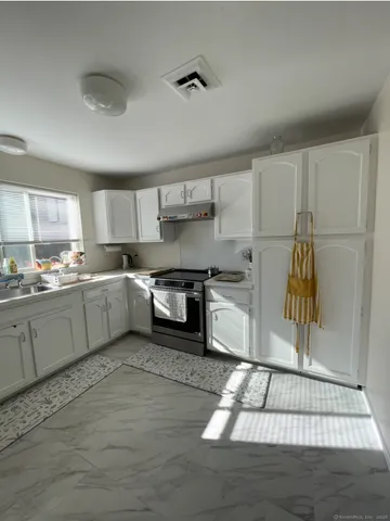 a kitchen with a refrigerator and white cabinets