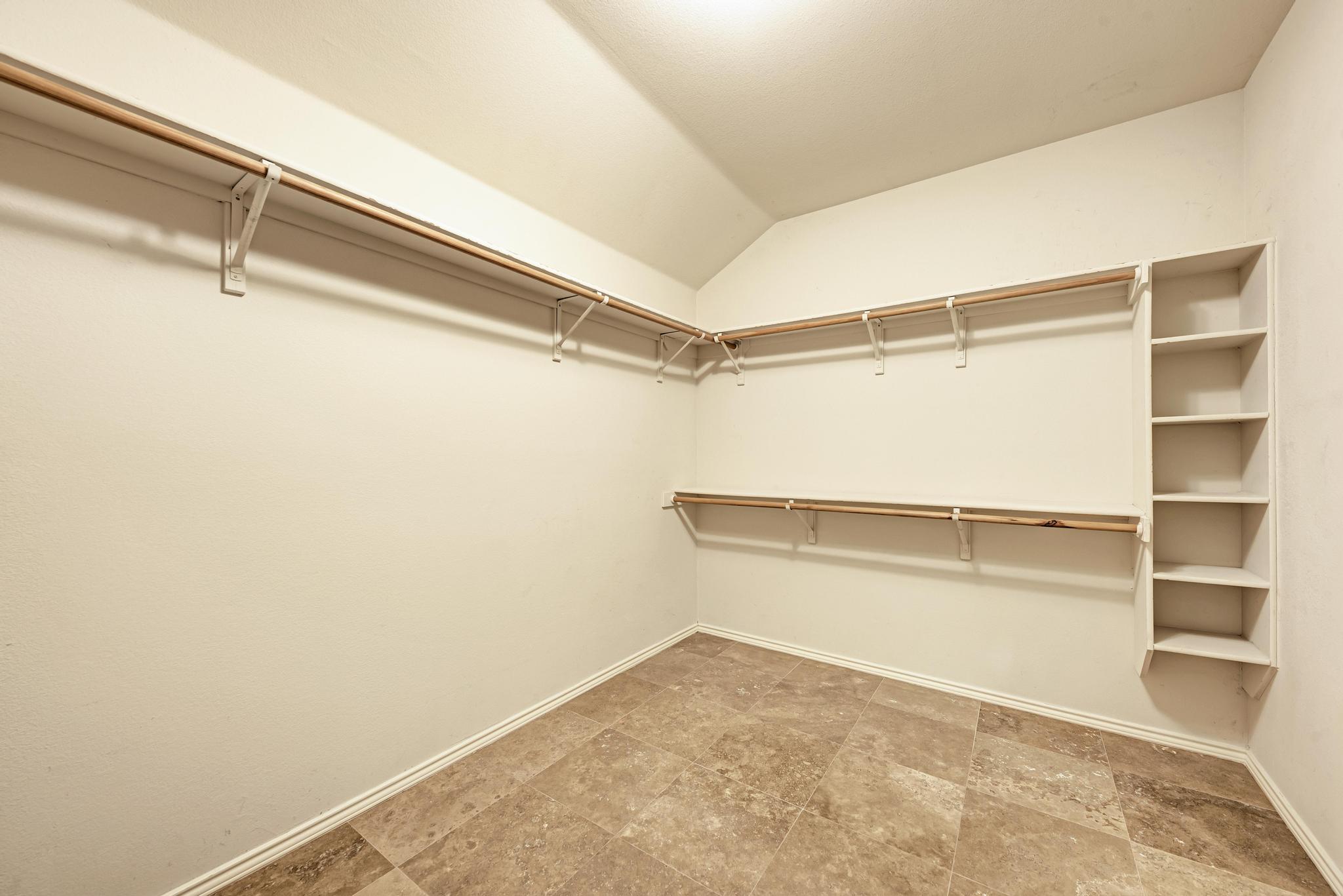 906 Antelope Ridge Cedar Park, TX 78613 - Photo 31 of 40 Ample built-in shelving and hanging rods maximize storage space over durable tile flooring.