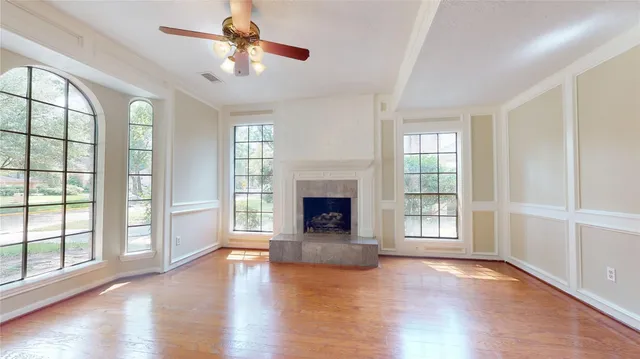 wooden floor fireplace and windows in an empty room