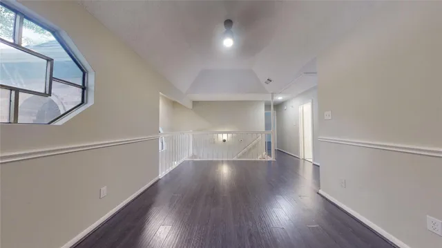 a view of a room with wooden floor and white walls