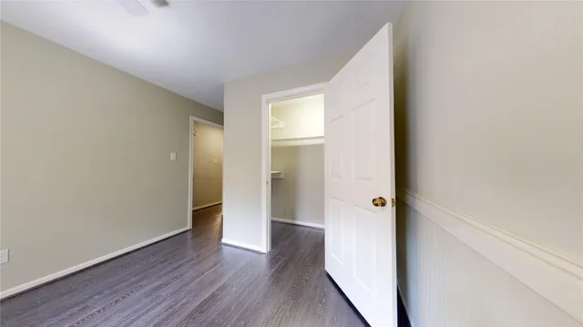 a view of an empty room with window and cabinet area