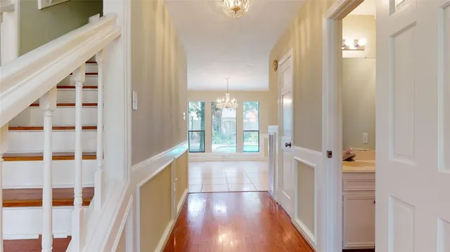 a view of a hallway with wooden floor and windows