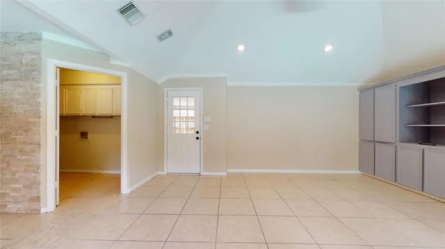 a view of an empty room with closet and a window
