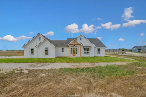 a view of a house with a yard and potted plants