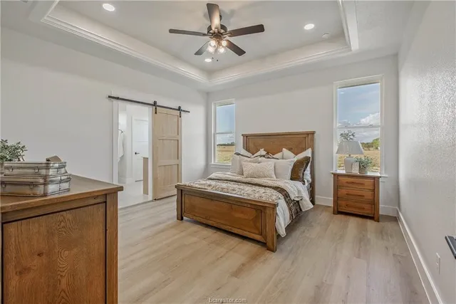 a spacious bedroom with a bed and a chandelier