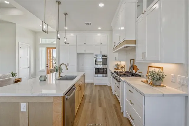 a kitchen with stainless steel appliances granite countertop a sink stove and refrigerator